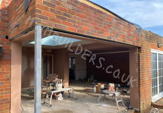A partially constructed building extension with tools and materials inside.