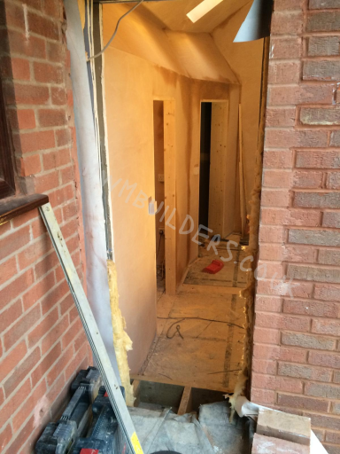 Interior view of a construction site with exposed walls and unfinished flooring.