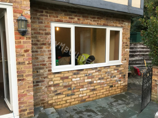 Window with a brick exterior, revealing an interior space with furniture visible.